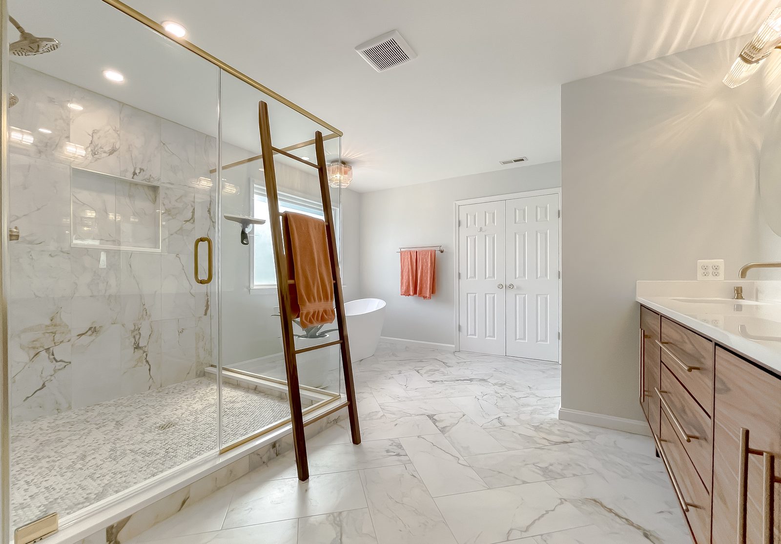 Marble walk-in shower with brass fixtures in a Leonardtown MD bathroom remodel